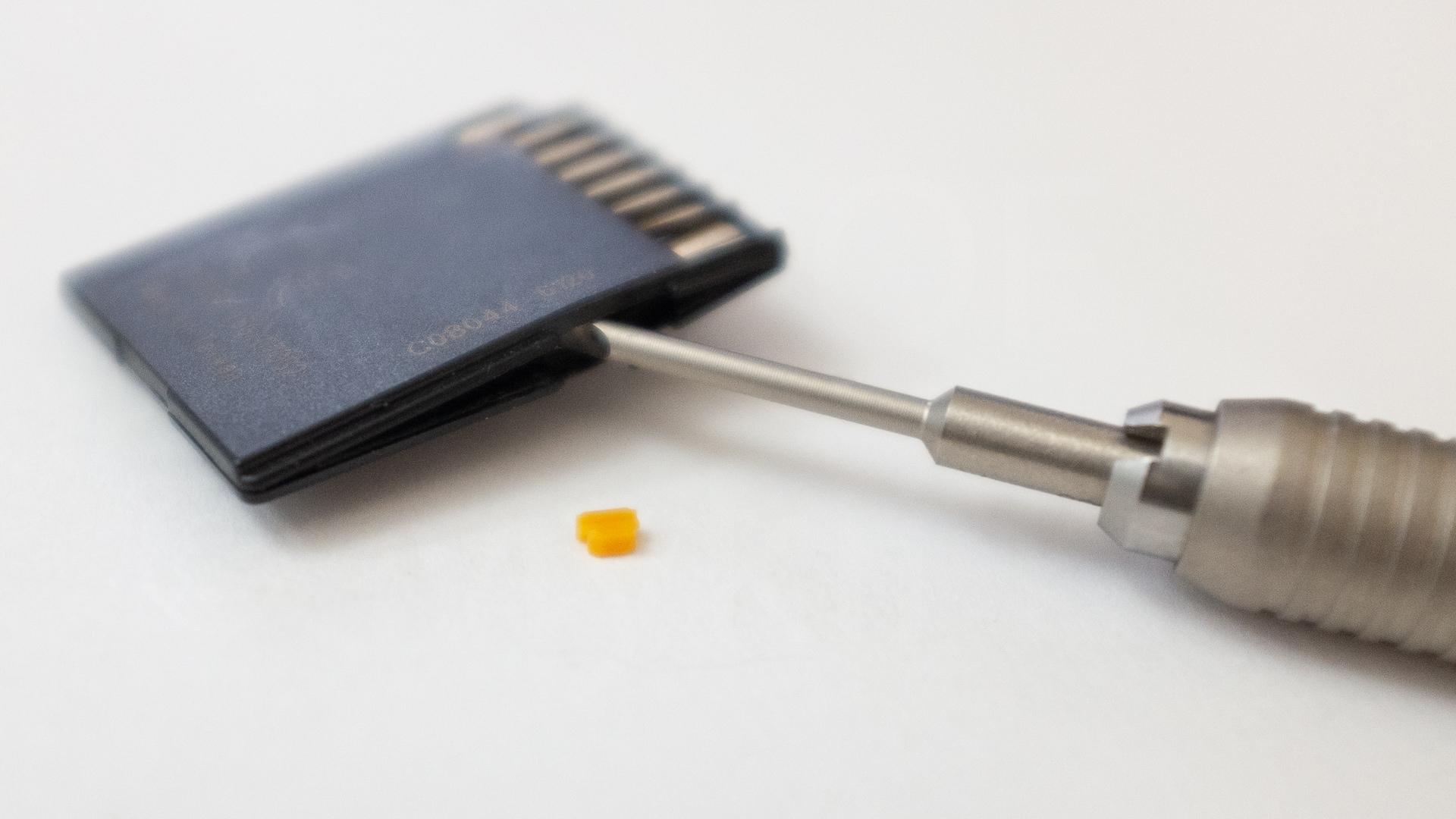 SD Card with switch taken out Image of SD Card with the switch removed and a screwdriver used to split the card.