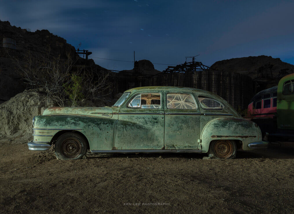 Night photo of abandoned vehicle in desert.